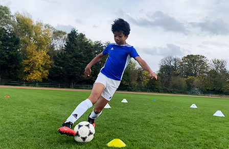 A young player practices control skills from a Family F.C. session.